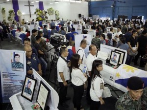Mourners pay their last respects to the 44 police anti-terror commandos who perished  last Sunday during the Philippines' biggest single-day combat loss in recent years,  at Camp Bagong Diwa, Taguig city, south of Manila, Philippines, on Friday, Jan. 30, 2015. On Friday, Philippine President Benigno Aquino III promised grieving relatives of the slain commandos that government forces will capture suspected bomb-maker Abdul Basit Usman. (AP Photo/Bullit Marquez)
