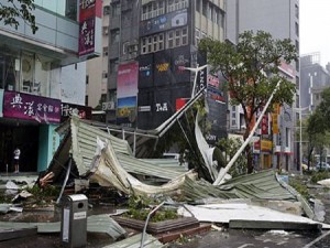 A street corner is filled with a mangled rooftop brought down by strong winds from Typhoon Soudelor in Taipei, Taiwan, Saturday, Aug. 8, 2015. Soudelor brought heavy rains and strong winds to the island Saturday with winds speeds over 170 km per hour (100 mph) and gusts over 200 km per hour (120 mph) according to Taiwan's Central Weather Bureau. (AP Photo/Wally Santana)