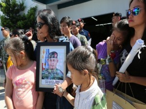 GOING HOME/ JAN 31,2015 the three childen of PO3 Kibete and relative carries his  picture outside the multi purpose hall of Camp Bagong Diwa.  Members of Special Action force and Police personels salutes while the vehicle carrying the body of P03 junrel Kibete is on the way out of the Camp . the family of PO3 kabete will bring him to his hometown  in Bulacan.  Kibete is one of the 44 SAF members killed in Mamasapano in maguindanao. INQUIRER PHOTO/JOAN BONDOC