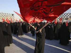 Iranian women wave flags that read, "Death to America and we shall never accept humiliation," during a rally to protest the execution by Saudi Arabia last week of Sheikh Nimr al-Nimr, a prominent opposition Saudi Shiite cleric, in Tehran, Iran, Monday, Jan. 4, 2016. Allies of Saudi Arabia followed the kingdom's lead and began scaling back diplomatic ties to Iran on Monday after the ransacking of Saudi diplomatic missions in the Islamic Republic, violence sparked by the Saudi execution of al-Nimr. (AP Photo/Vahid Salemi)