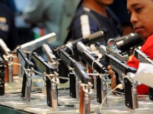 A man looks at .45 caliber handguns for sale at the 18th Defence and Sporting Arms show at a mall in Manila on July 15, 2010. There are more than 1.2 million unlicensed guns and 1.8 million registered ones in the Philippines, out of a population of 90 million people, according to police estimates. AFP PHOTO/TED ALJIBE