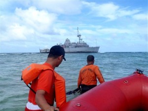 In this Jan. 22, 2013 photo released by the Philippine Coast Guard, coast guard divers approach the USS Guardian, a US Navy minesweeper, to assess the situation after it ran aground last week off Tubbataha Reef, a World Heritage Site in the Sulu Sea, 640 kilometers (400 miles) southwest of Manila, Philippines. A US. Navy official said the USS Guardian has been punctured and taking in water and has to be lifted off the rocks. (AP Photo/Philippine Coast Guard) EDITORIAL USE ONLY, NO SALES