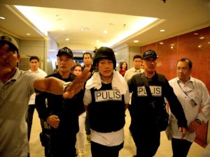 Police officer Ricky Sta. Isabel (C), one of the suspects in the kidnapping and murder of South Korean businessman Jee Ick Joo, is escorted by fellow policemen as they leave the National Bureau of Investigation (NBI) building in Manila on January 20, 2016.  A South Korean businessman kidnapped by Philippine policemen under the guise of a raid on illegal drugs was murdered at the national police headquarters in Manila, authorities said Thursday. / AFP PHOTO / NOEL CELIS
