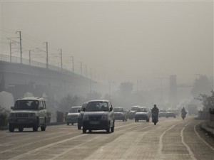 Vehicles move through morning smog on the first day of a two-week experiment to reduce the number of cars to fight pollution in New Delhi, India, Friday, Jan. 1, 2016. The volunteers are meant to encourage people to fall in line with the governments plan to allow private cars on the roads only on alternate days from Jan. 1-15, depending on whether their license plates end in an even or an odd number. (AP Photo/Altaf Qadri)