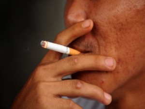 A man holds a cigarette as he smokes in his house in Manila on May 29, 2011. Authorities in the Philippine capital Manila have announced a drive to strictly enforce a smoking ban in public places across the sprawling metropolis. The Metropolitan Manila Development Authority said that from May 30, 2011 it would deploy policemen and specially trained enforcers across the city of 12 million people to round up violators. AFP PHOTO/NOEL CELIS