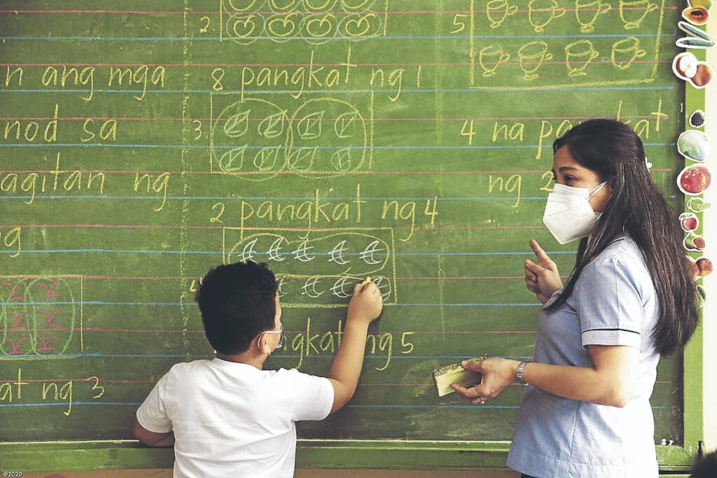 PHOTO: Teacher with student at blackboard STORY: 4 na oras na pagtuturo ng mga guro ipinanukala ni Gatchalian