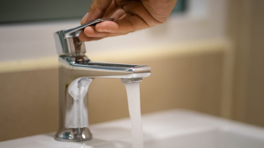 PHOTO: Stock image of hand opening a faucet