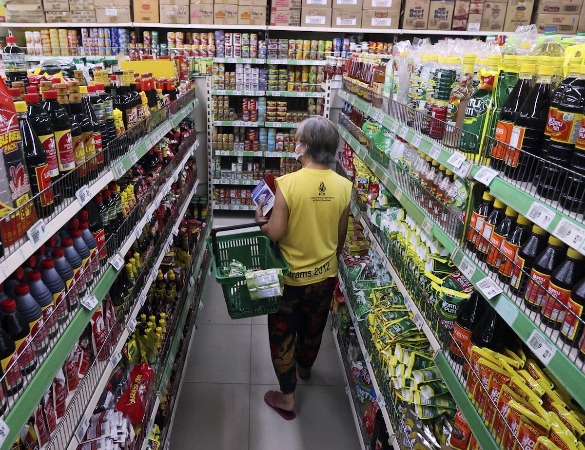 PHOTO: Woman at aisle of grocery store STORY: Dinagdagán ng iláng pábrika produktong kusang naka price freeze