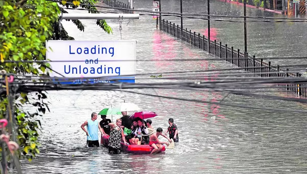 PHOTO: People on a raft on flooded España Boulevard STORY: Patay sa Typhoon Carina nasa 21 na, ayon sa PNP